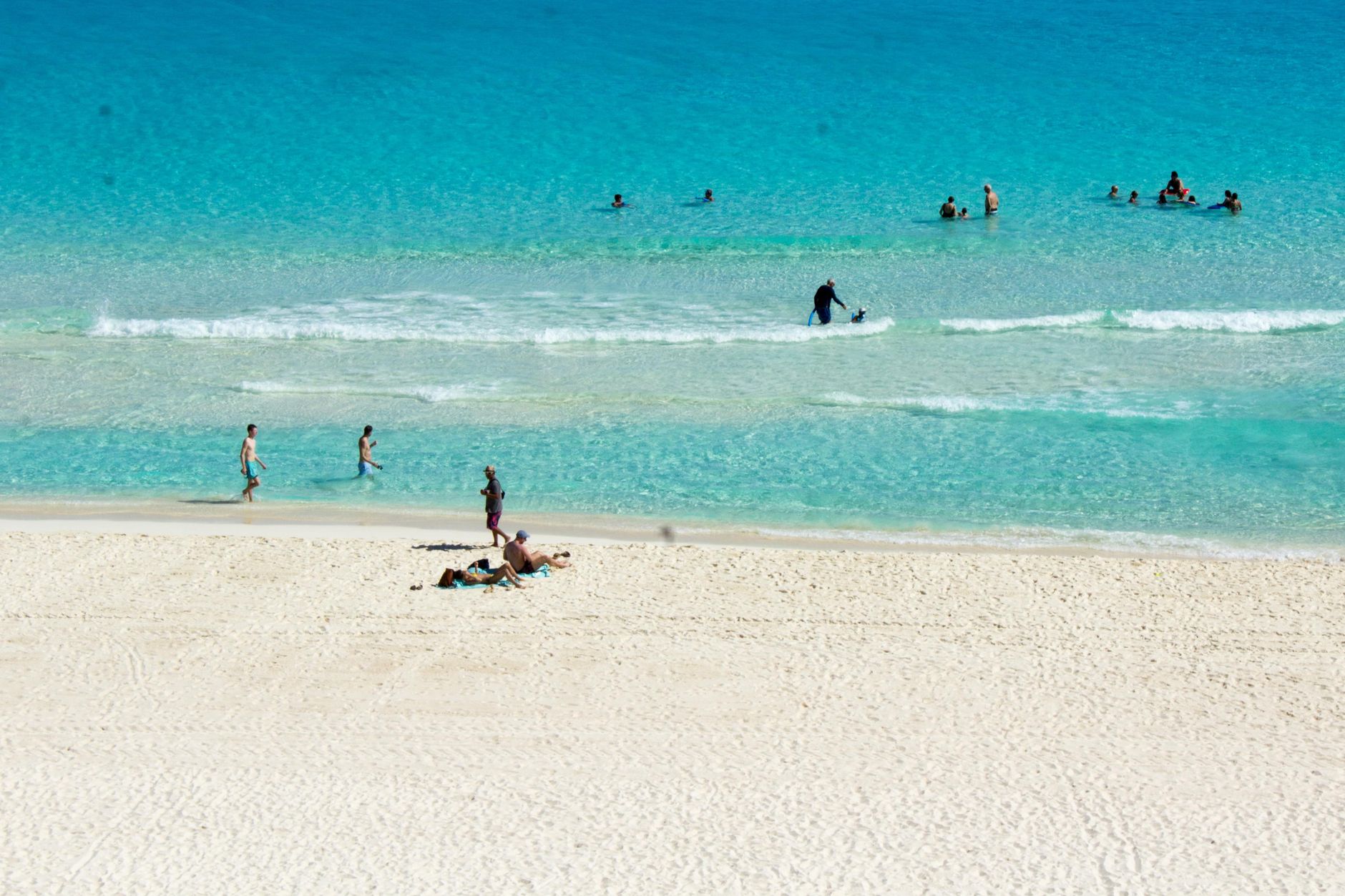 Wide stretch of pale sand meeting shallow turquoise water