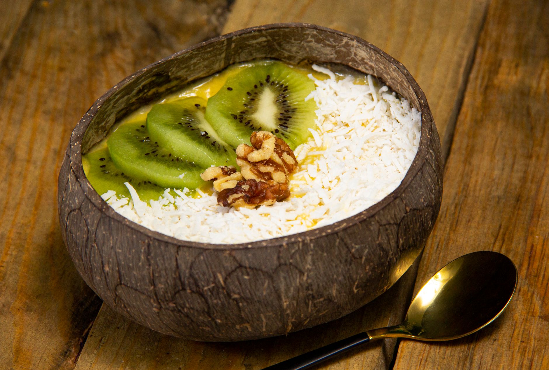 Tropical fruit and coconut breakfast bowl on a rustic table